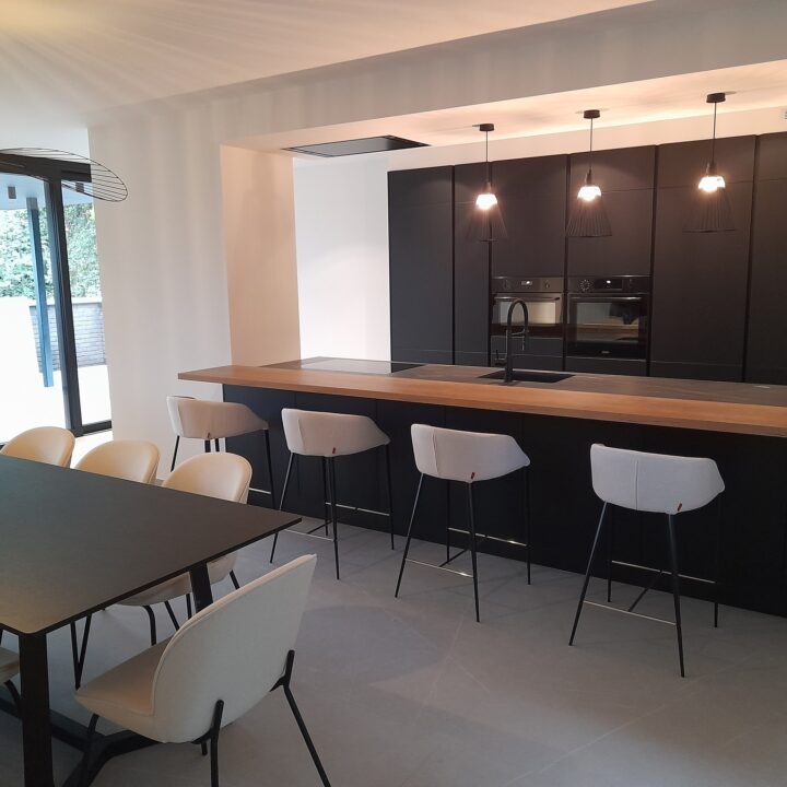 Cuisine noir mat (sans poignée) – Plan de travail en Dekton (céramique) LAURENT (veiné) et Table en repose imitation bois Chêne